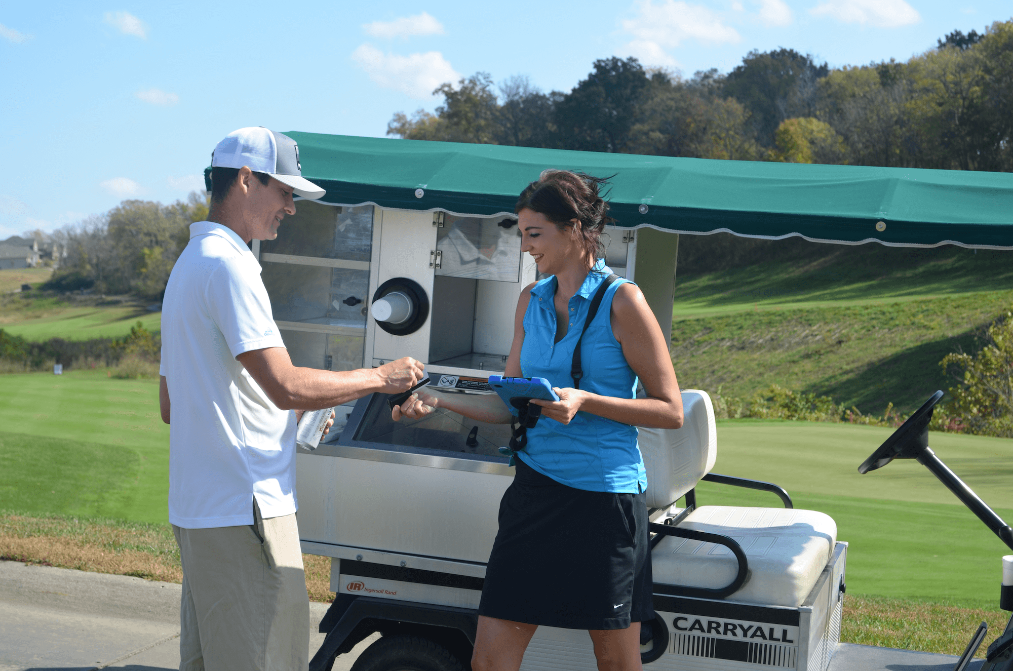 Shot of a woman using TeeQuest's beverage cart tablet to sell a man some delicious beers.